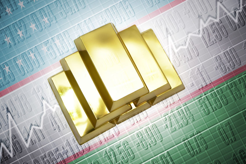 Lingotes de oro sobre una bandera de Uzbekistán