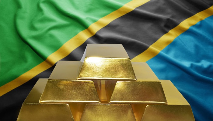 Lingotes de oro con la bandera de Tanzania de fondo