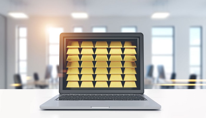Lingotes de oro en la pantalla de un ordenador portátil