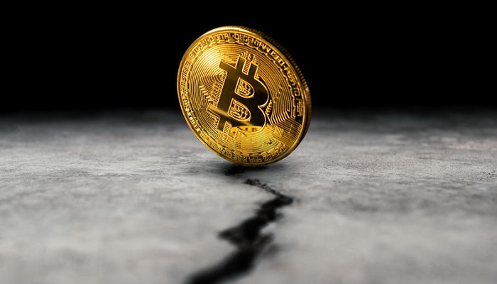 Moneda de bitcoin sobre una grieta