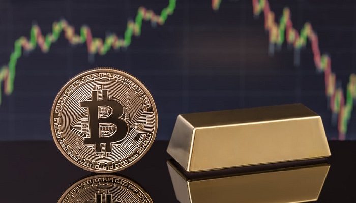 Bitcoin y lingote de oro con un gráfico al fondo