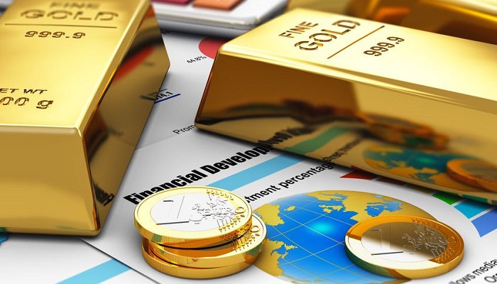Lingotes de oro y monedas de euros sobre mapa del mundo