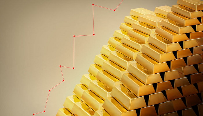 Montaña de lingotes de oro y gráfico de subida del precio
