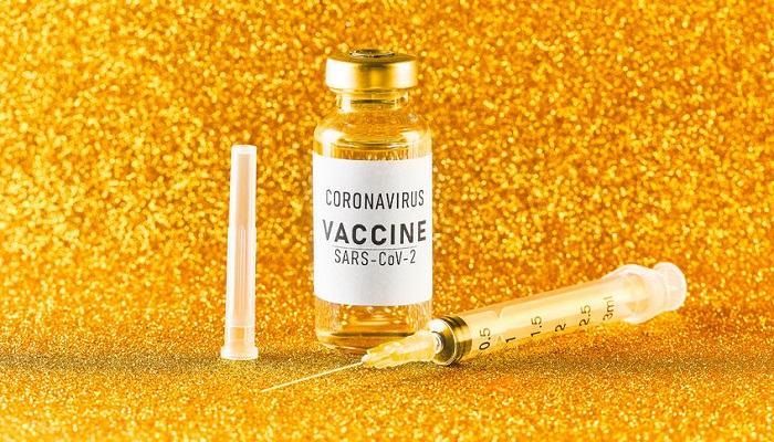 Vacuna contra el Covid-19 sobre fondo de oro