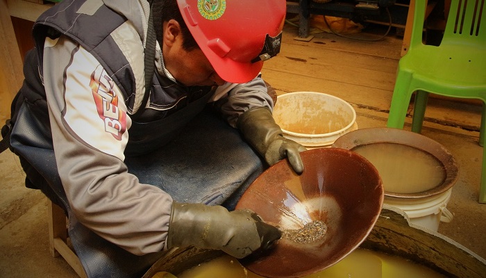 Minero artesanal bateando oro en Perú